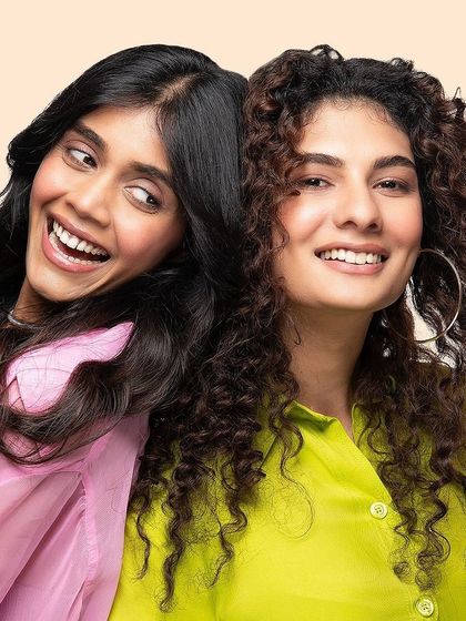 A joyful lifestyle shot for Arata, featuring two models with different hair types to showcase the brand's inclusive approach to hair care.