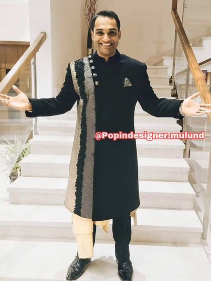 This client looks fantastic in a black asymmetrical sherwani with gold and silver detailing. It’s a unique design that’s perfect for a groom or a wedding guest.