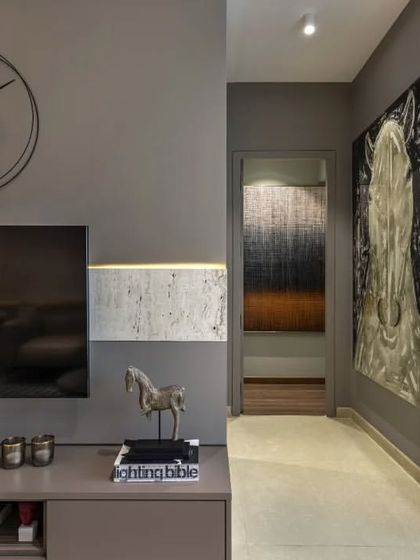 Another perspective of the grey-toned apartment, highlighting the use of art and decor to add personality. The large abstract painting and the sculptural clock are not just decorations; they are integral components of the room's narrative.