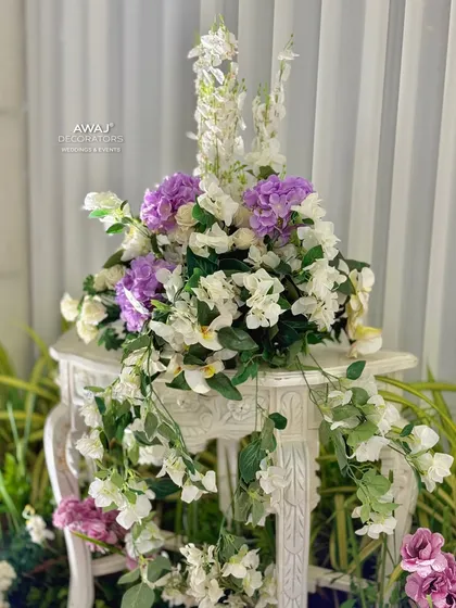 A delicate floral arrangement on a classic white pedestal, a small but elegant detail in the entrance decor.