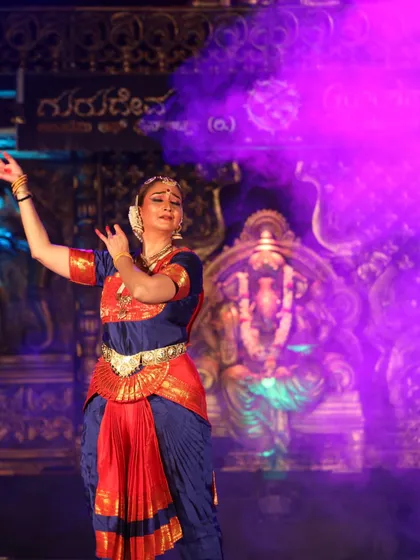 A moment of serene devotion. The combination of the pose, expression, and stage lighting creates a truly divine atmosphere during a performance.
