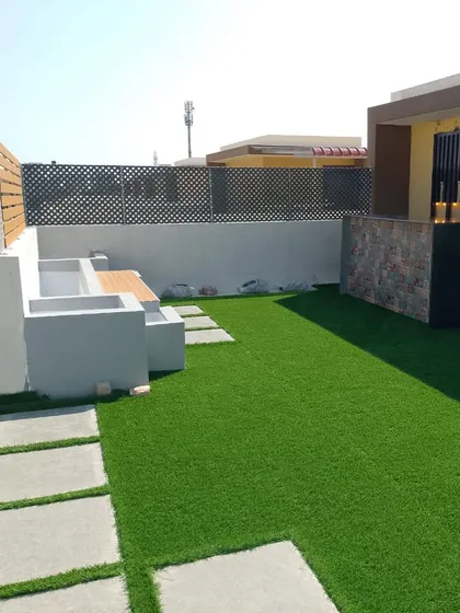 This shows the start of a great party place on a roof. We've laid down lush artificial grass and added built-in seating, creating a foundation for a versatile space for kids' parties or family get-togethers.