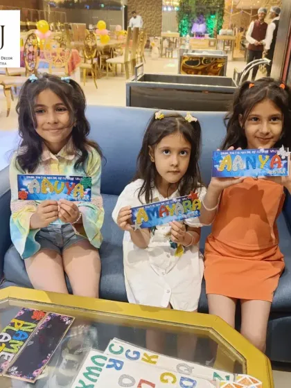 Young guests showing off the personalized nameplates they created during the party. It's a creative activity that keeps children happily engaged.