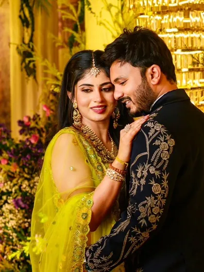 A beautiful moment between a couple at their celebration. Her lime green embroidered lehenga and his navy embroidered sherwani are a perfect example of how I coordinate outfits for the bride and groom.