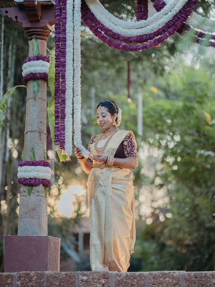 This bride is getting ready for her wedding. Her look is traditional and elegant, with a focus on her beautiful jewelry and the rich color of her silk saree.