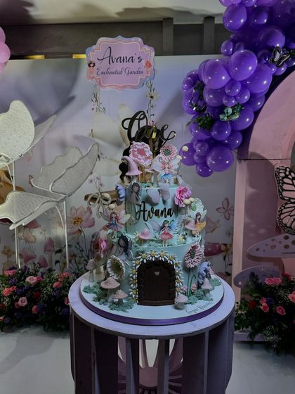 Another view of the multi tiered fairy house cake, showcasing the intricate details and decorations that tie into the enchanted garden theme.