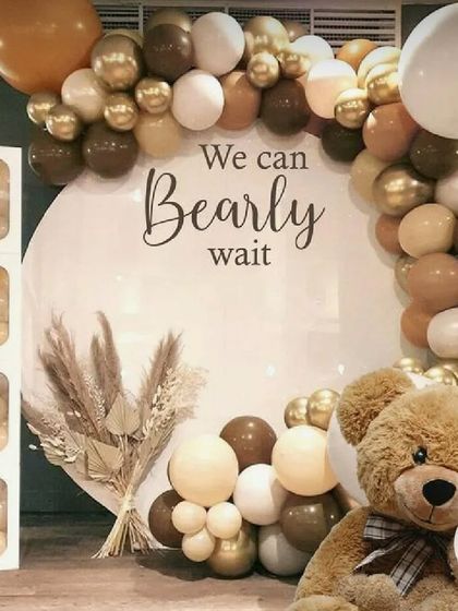 A trendy "We Can Bearly Wait" baby shower theme with a neutral color palette of brown and beige balloons, a teddy bear, and pampas grass.