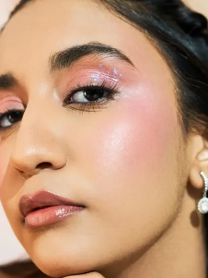 Here we added a touch of iridescent glitter over the pink eyeshadow for a bit of magic. The skin remains the focus with its incredible glow.