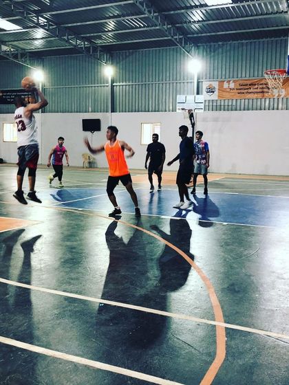A player elevates for a jump shot during a game. Our well-maintained hard court is designed for dynamic and safe basketball action.