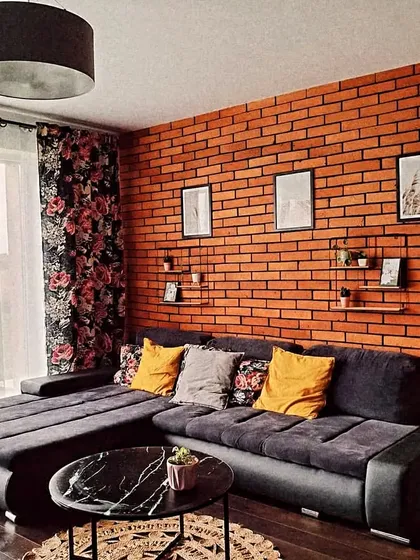 An exposed brick accent wall adds a touch of urban chic to this living room, providing a textured canvas for artwork and shelving.