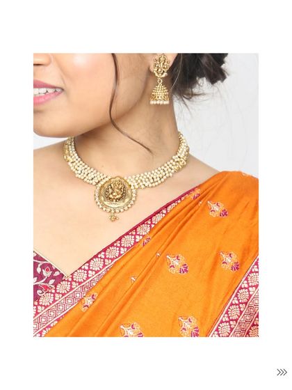A close-up of a traditional temple jewellery choker with a goddess motif, paired with matching jhumkas. This style of jewellery adds a divine and auspicious touch to any ethnic wear, especially for weddings and festivals.
