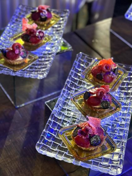 A beautiful assortment of mini fruit tarts. The glistening fruits on a creamy base make for an irresistible and refreshing dessert option.