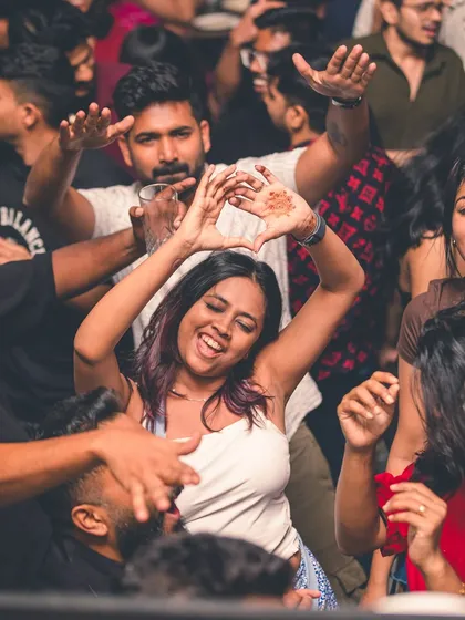 A fan making a heart sign with her hands, showing love for the music and the vibe.