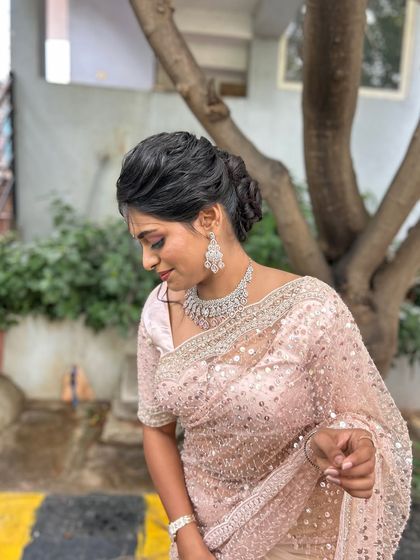 The client looking elegant with her textured updo, paired with a sparkling saree and diamond jewellery.