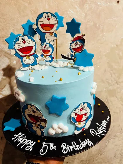 A fun Doraemon-themed cake, covered in characters and stars for a 5th birthday celebration.