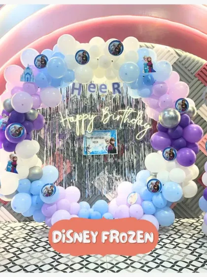 An enchanting Disney Frozen birthday setup! This beautiful balloon arch with Anna and Elsa cutouts creates the perfect icy kingdom for a magical celebration.