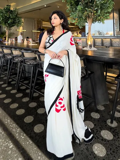A modern saree look perfect for a special date night or a chic lunch. I believe in creating outfits that are memorable, combining unique pieces like this hand-painted saree with a contemporary halter-neck blouse and a structured bag for that clean, crisp, and confident vibe.