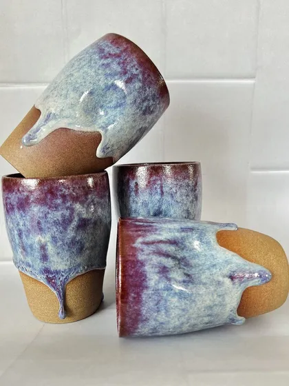 I designed these grip tumblers to fit perfectly in your hand. The beautiful, drippy glaze is a mix of deep purples and blues, making each stoneware cup a unique piece of functional art.