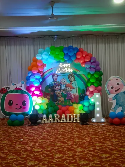 For a child's first birthday, I created this vibrant Cocomelon themed stage decoration. It features a colorful balloon arch, a personalized backdrop with the birthday boy's name, character cutouts, and a light-up number '1' to make the celebration extra special.