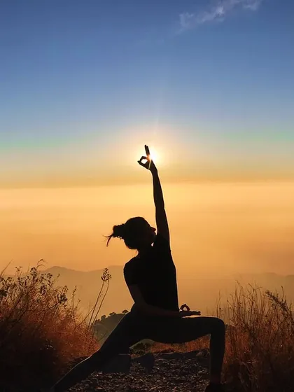The Gyan mudra in this Reverse Warrior pose signifies knowledge and concentration. Practicing it against the backdrop of a Himalayan sunset helps to focus the mind and absorb the wisdom of the mountains.
