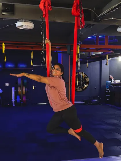 Aerial yoga is for everyone, regardless of age or experience. Here, a client gracefully holds a supported pose, demonstrating the balance and poise you can develop in my classes.
