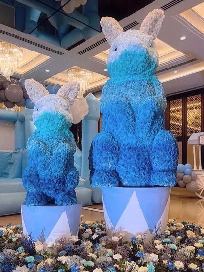 Giant floral bunnies in shades of blue and white add a soft, whimsical touch to the carnival theme. These custom floral sculptures are a unique way to incorporate flowers into a child's party.