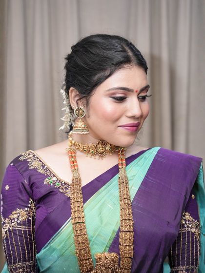 A soft and subtle take on the South Indian look. The makeup features a gentle pink eyeshadow and a matching lip, creating a fresh and youthful appearance.