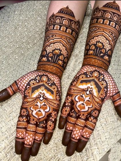 This design has a beautiful stained effect, with peacock and lotus motifs on the palm and palace architecture on the forearms.