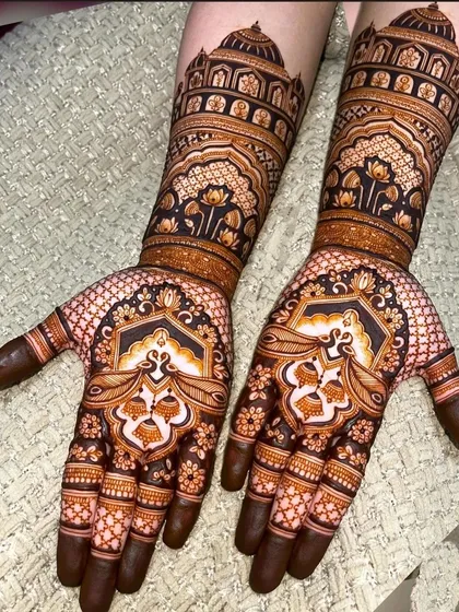 This design has a beautiful stained effect, with peacock and lotus motifs on the palm and palace architecture on the forearms.