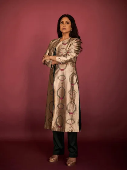 A powerful, arms-crossed stance that emphasizes the structured feel of this elegant Indian-wear jacket.