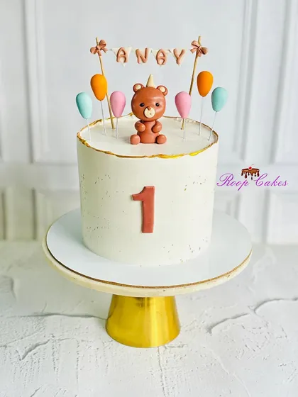 Sweet and simple. A charming teddy bear cake to celebrate a baby's very first birthday, featuring a cute fondant bear and colorful balloons.