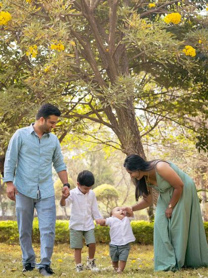 A candid shot of the family walking together in the park, holding hands.