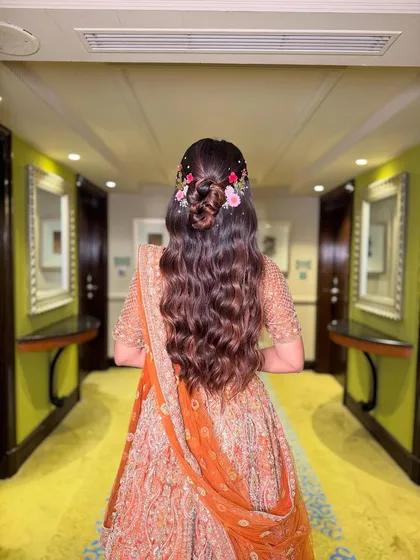 For a dreamy and romantic vibe, I styled these long, flowing waves into a half-up bun, delicately weaving in fresh flowers. This look is effortlessly beautiful and perfect for an outdoor or daytime ceremony.