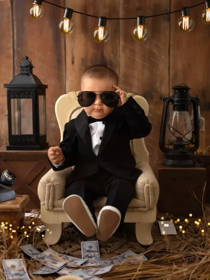 A little one dressed in a sharp tuxedo and sunglasses for a "Boss Baby" themed photoshoot. My prop-based studio sessions are a fun way to celebrate milestones and create unique portraits.