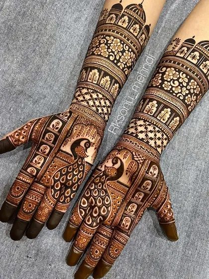 A celebration of classic Indian bridal art, this design features majestic peacocks as the centerpiece on both hands. The full-arm coverage includes architectural domes, floral bands, and fine line work, perfect for a traditional wedding ceremony.