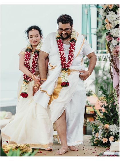 The couple walks together after a ritual at their South Indian beach wedding. The candid nature of the shot captures their relaxed happiness.