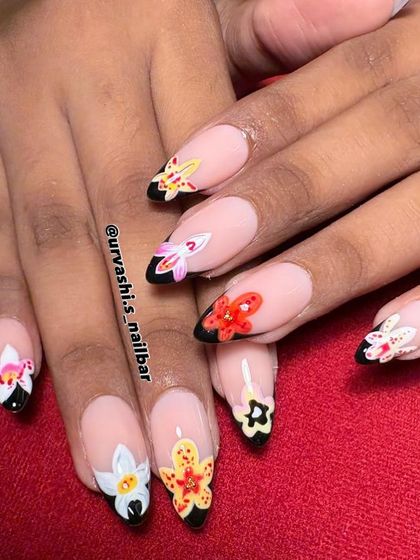 A bold and beautiful design featuring colorful 3D flowers on sharp, black-tipped nails. The contrast between the dark tips and the bright, blooming flowers gives this set a unique attitude.