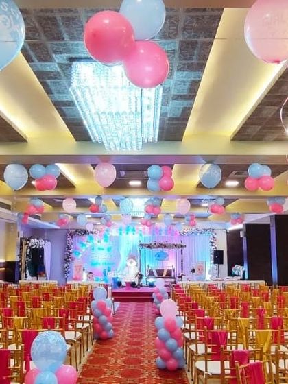 A baby shower or birthday party setup at Celebration banquet hall. The hall is filled with pink and blue balloons, creating a festive and cheerful environment for the celebration.