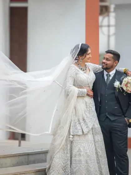 A stunning portrait with the bride's veil flowing in the breeze. This shot combines the elegance of a traditional wedding with a dynamic, modern feel.