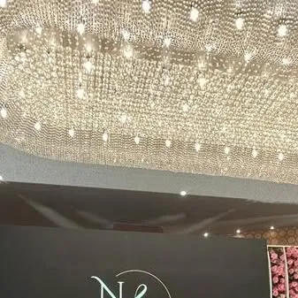 The magnificent crystal chandelier that served as a centerpiece for the venue's ceiling. We often use lighting as a key element to create a luxurious and grand atmosphere.