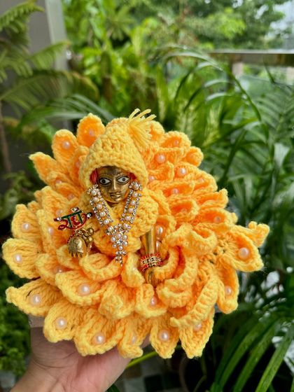 A bright and sunny yellow floral dress for Kanha Ji, looking like a marigold. The delicate pearl accents add a touch of elegance.