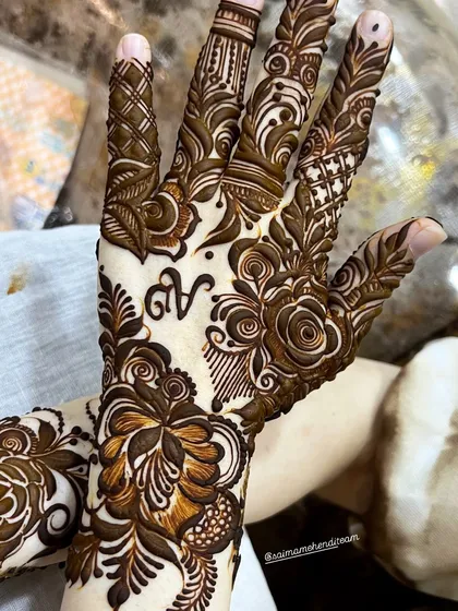 I love making my designs personal for you. Here, I've woven the initial 'N' into a dense floral and rose pattern, making the mehendi unique and meaningful for the wearer.