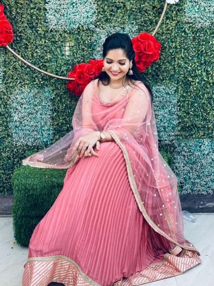 A simple and elegant pleated pink gown with a delicate embroidered border. This is a comfortable and chic rental option for any party.