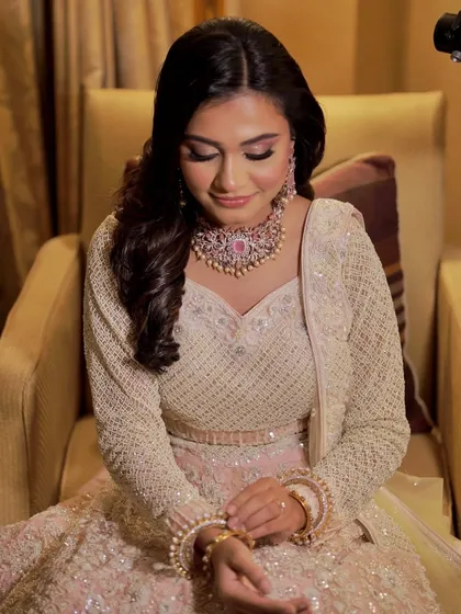 A beautiful bride getting ready for her reception. The look is soft and romantic with a pink-toned makeup palette.