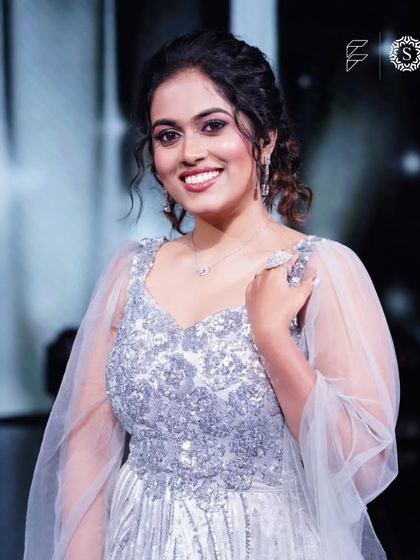 A close-up of Sayli Kamble smiling, wearing our simple diamond necklace and earrings with her silver gown. It shows how our jewellery can complete a party look.
