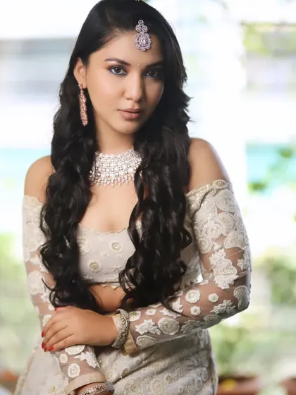 A stunning look from a professional photoshoot. This modern bridal style features soft waves, a diamond-dusted makeup look, and an off-shoulder lace blouse.