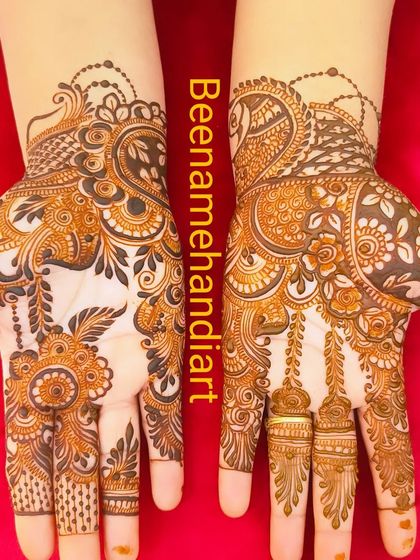 A pair of hands with elegant and flowing Arabic mehandi. The design is light but covers the hand beautifully.