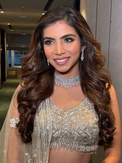 A happy, confident bride. Her smile and radiant makeup are the perfect accessories for her glamorous reception outfit.