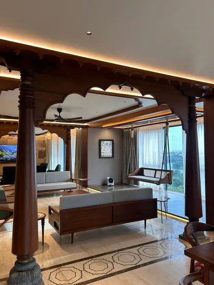 In this Bengaluru apartment, we integrated traditional Indian architectural elements within a contemporary living space. The intricately carved wooden pillars and oonjal (swing) create a focal point, celebrating heritage while maintaining a modern, open-concept feel.