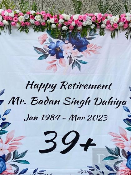 A personalized backdrop for a retirement party, honoring Mr. Badan Singh Dahiya. The floral design and custom text create a respectful and celebratory focal point for the event.